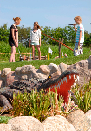 Crocodile in front of kids playing golf